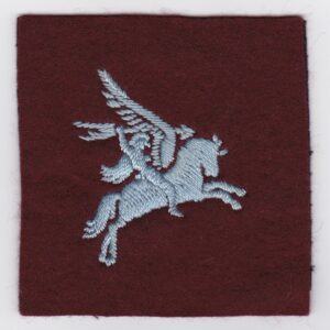 A badge with an image of a horse on a maroon background.