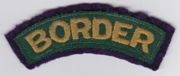 A green and purple border patch on a white surface.