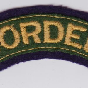 A green and purple border patch on a white surface.