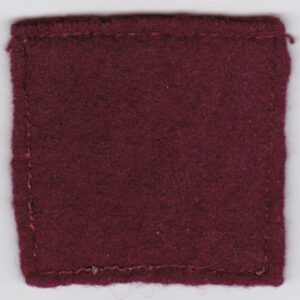 A burgundy felt patch on a white surface.