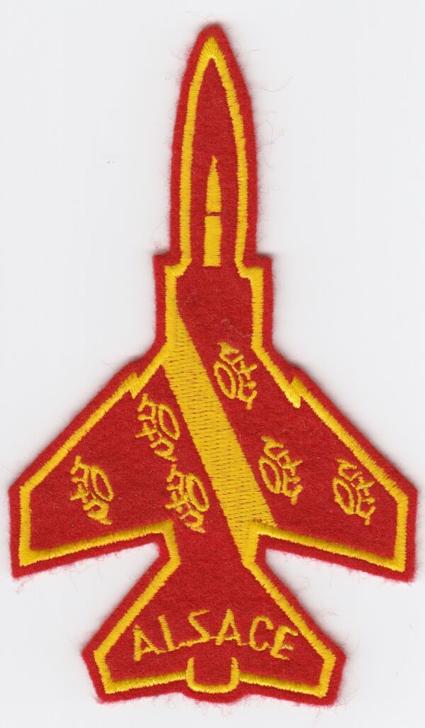 A red and yellow fighter jet embroidered on a white surface.