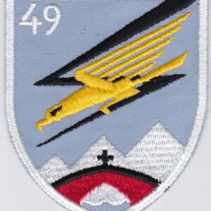 A patch with an image of a plane flying over a mountain.