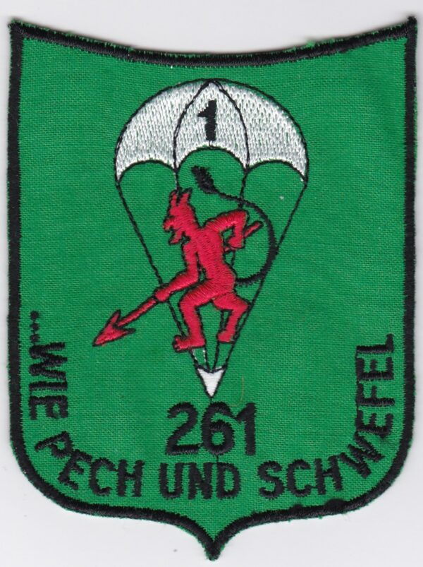 A green patch with an image of a devil and a parachute.