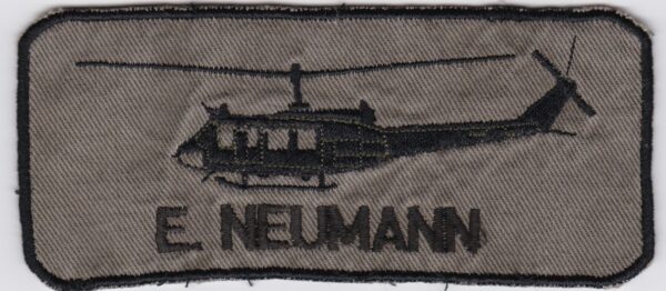 A patch with the name e nelman on it.