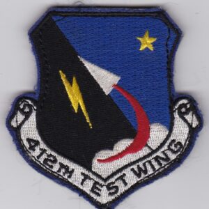 An air force test wing patch on a white surface.