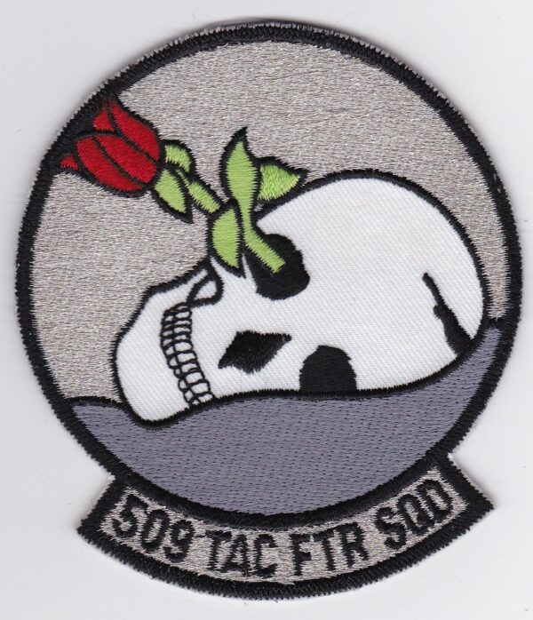 A patch with a skull and a rose on it.