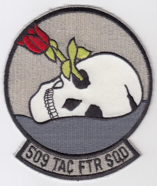 A patch with a skull and a rose on it.