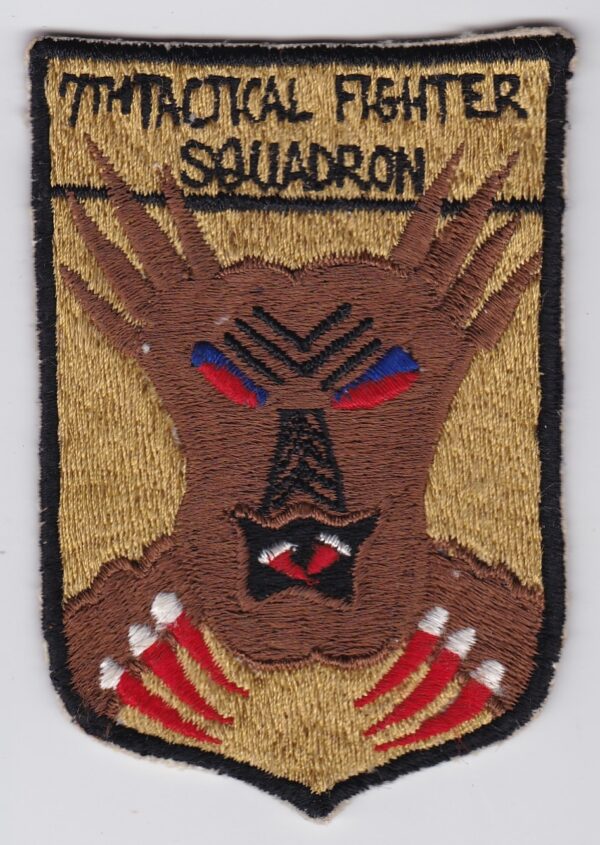 USAF 7 Tactical Fighter Squadron FTS Patch USAFE F 105 Thud Japanese hand machine embroidered depicting a mainly brown Bunyip an aboriginal death demon mask on a gold shield with the words 7th Tac Fighter Squadron above