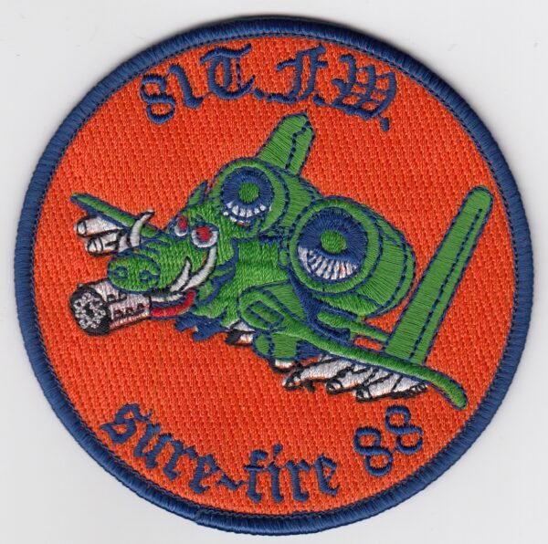 A patch with an image of an orange and green fighter jet.