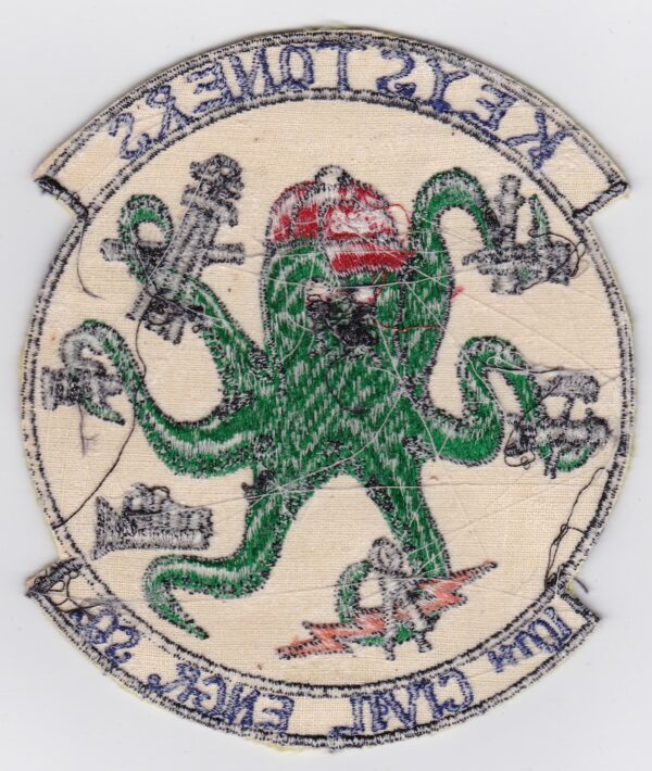 Green octopus holding tools, squadron patch.