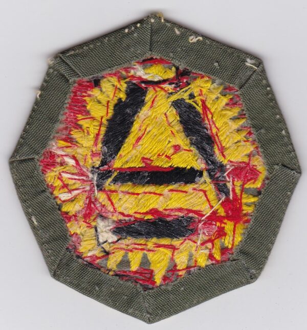 Embroidered patch with a yellow triangle.