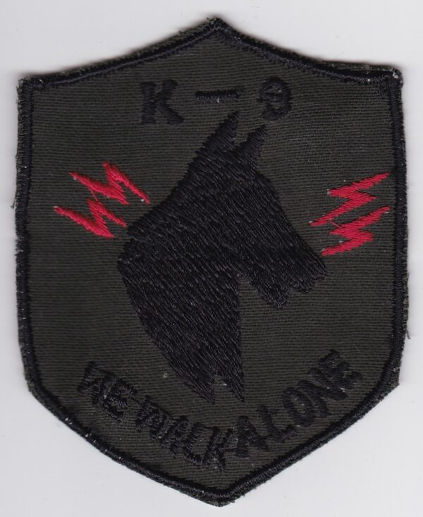 A patch with the words k-9 we walk alone.